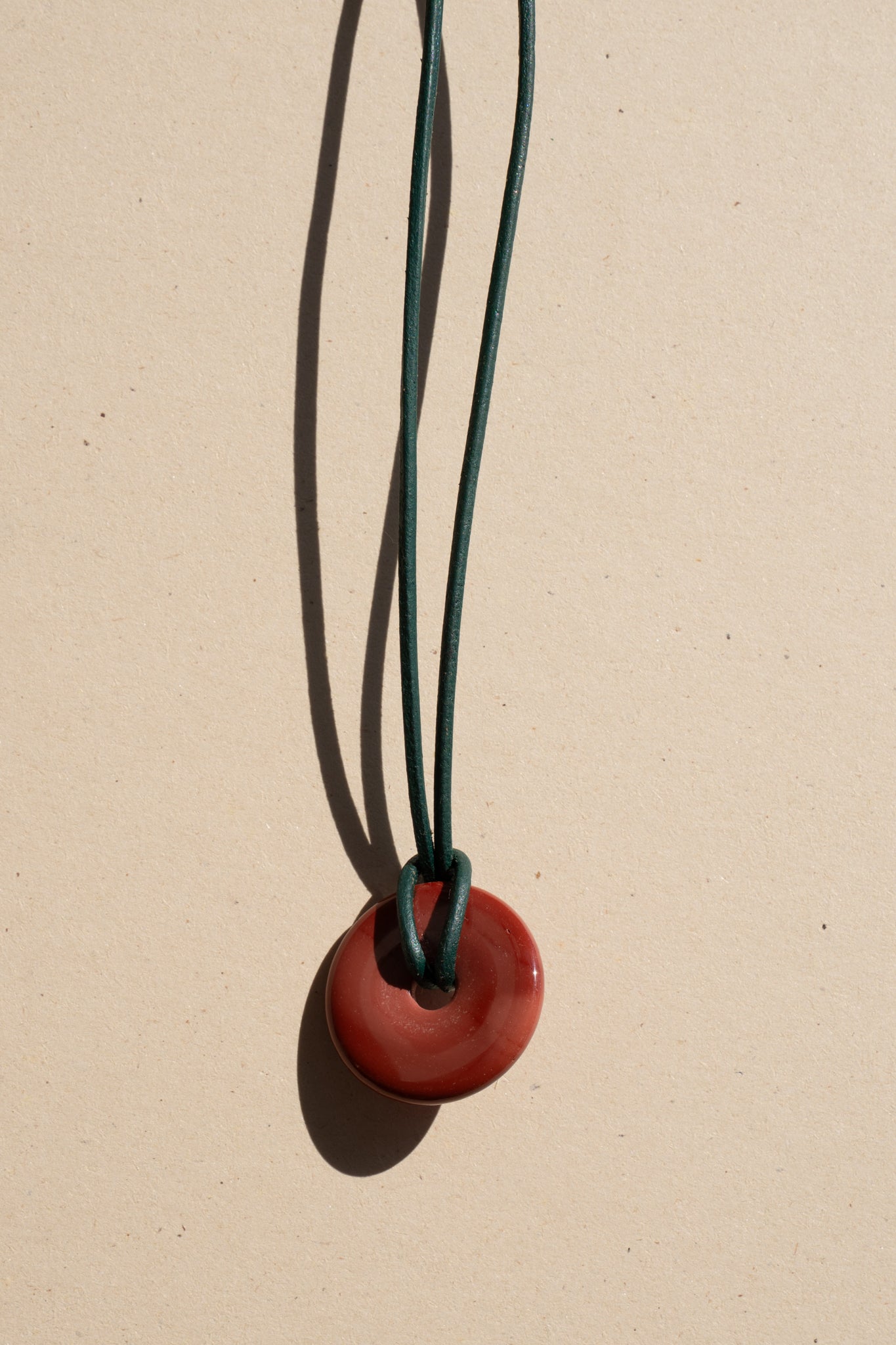 Red Jasper Donut on Green Leather
